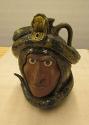 Face jug with snake