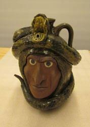Face jug with snake