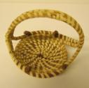 Gullah coil basket with arched handle and rime studded with four pine needle knots