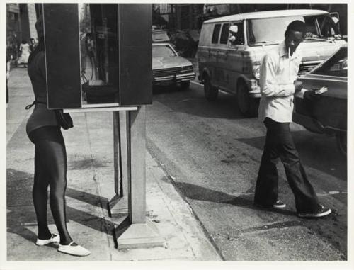 52nd St. and Madison Ave., New York, NY (telephone booth, black man smoking, looking at woman)