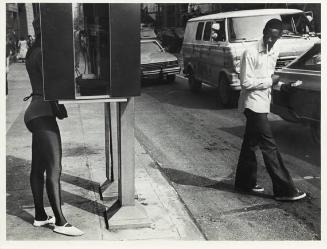 52nd St. and Madison Ave., New York, NY (telephone booth, black man smoking, looking at woman)
